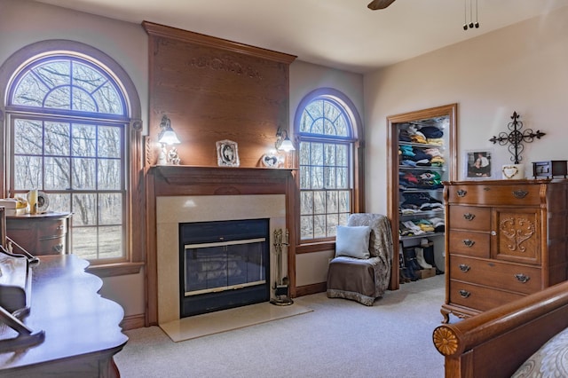 living area featuring a healthy amount of sunlight, ceiling fan, and light carpet