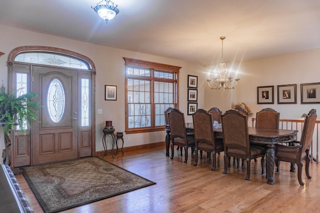 entryway with wood-type flooring and a notable chandelier