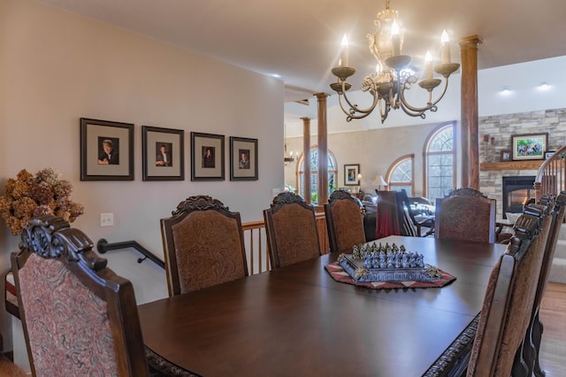 dining room with a fireplace, hardwood / wood-style floors, and ornate columns