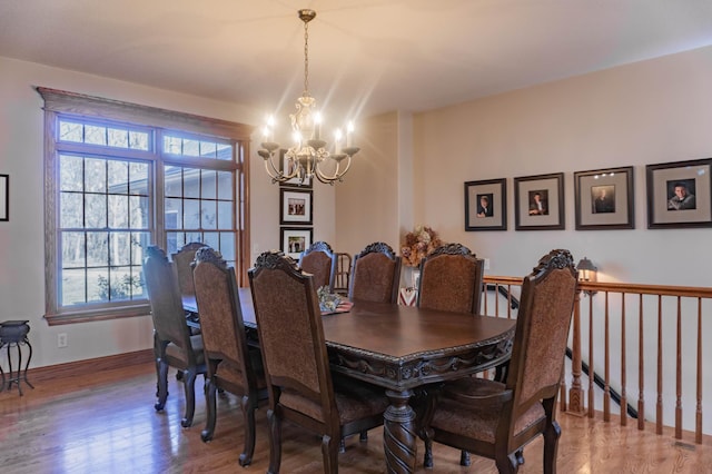 dining area featuring hardwood / wood-style floors and a notable chandelier