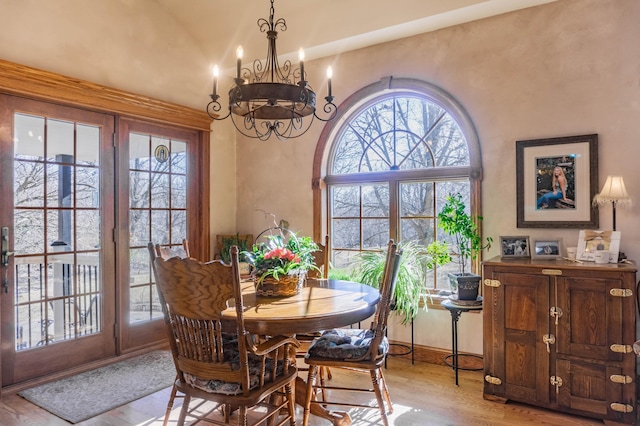 dining space featuring a notable chandelier, light hardwood / wood-style flooring, and french doors