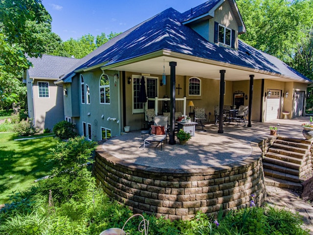 back of house with a lawn, a garage, and a patio