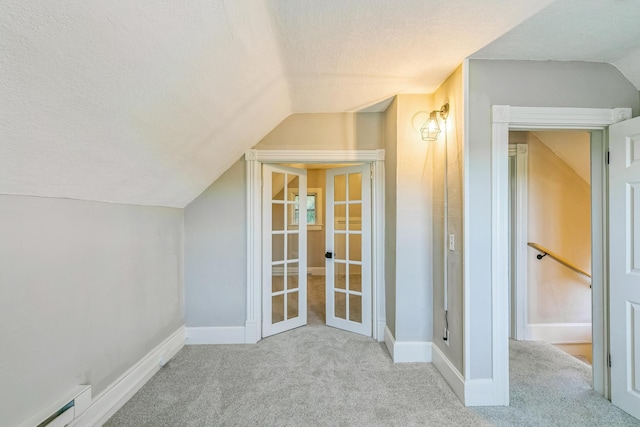 bonus room with light carpet, a textured ceiling, baseboard heating, and lofted ceiling