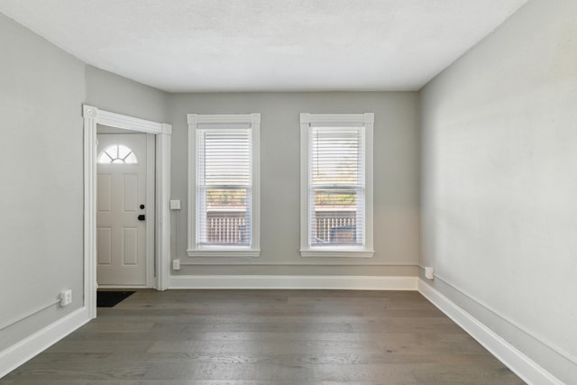 foyer entrance featuring dark wood-type flooring and a textured ceiling