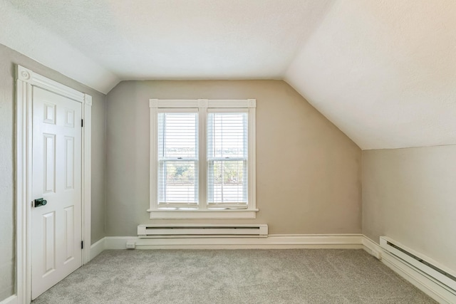 additional living space with light carpet, baseboard heating, and vaulted ceiling