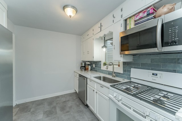 kitchen with stainless steel appliances, backsplash, sink, and white cabinetry