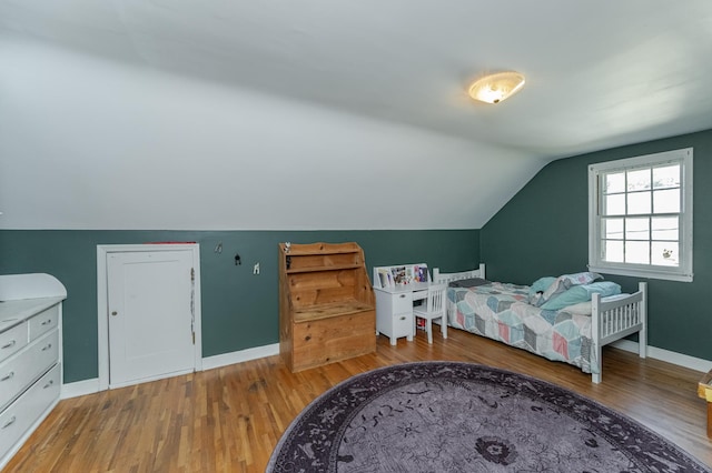 bedroom with lofted ceiling and hardwood / wood-style floors