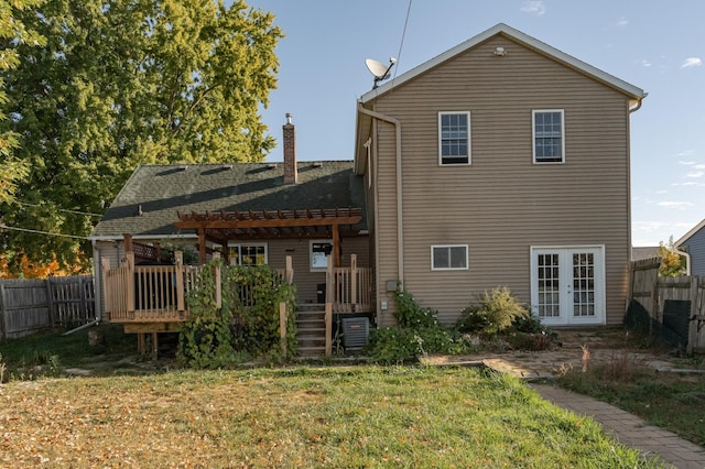 rear view of property with a wooden deck, a lawn, and a pergola