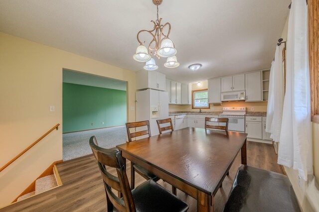 dining space with sink, a chandelier, and hardwood / wood-style flooring