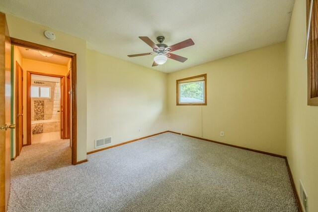 empty room featuring ceiling fan and light colored carpet