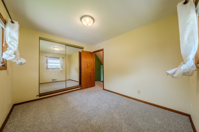 unfurnished bedroom with carpet floors and a closet