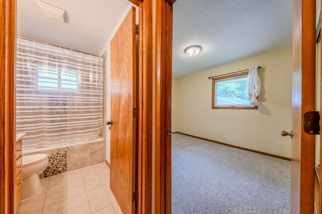 full bathroom featuring shower / tub combo, a textured ceiling, vanity, tile patterned flooring, and toilet