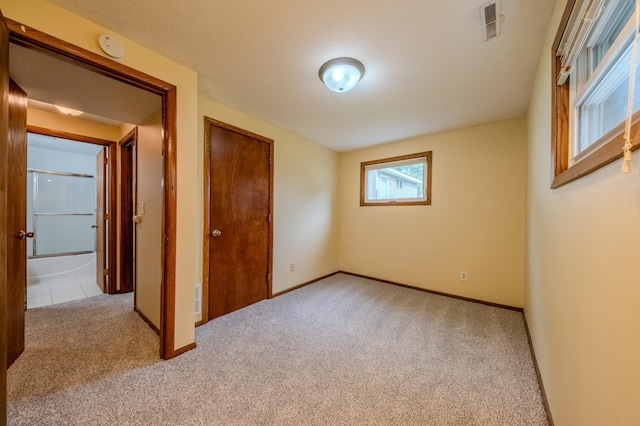 empty room featuring light carpet and a textured ceiling