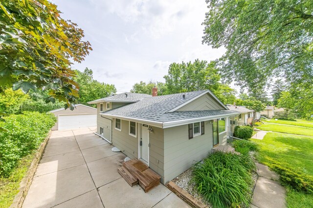 exterior space with a lawn, a garage, and an outdoor structure