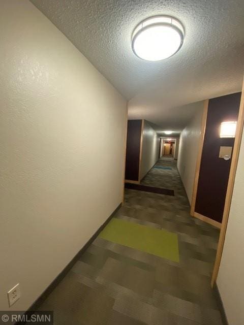 corridor featuring a textured ceiling and lofted ceiling