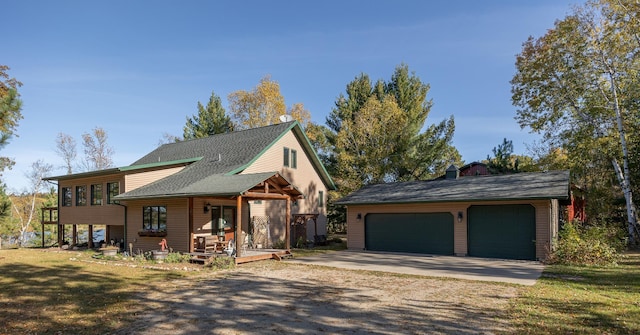 view of front of home with an outbuilding, a porch, a front yard, and a garage