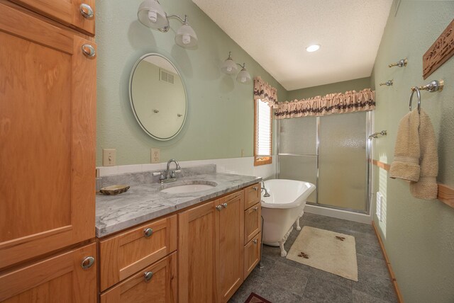 bathroom featuring plus walk in shower, vanity, and a textured ceiling