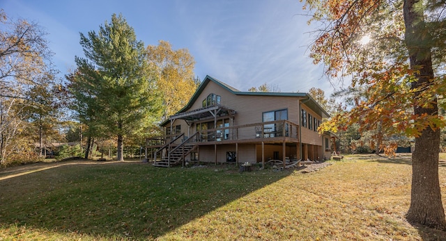 rear view of house with a wooden deck and a lawn