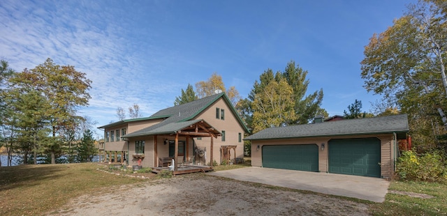 view of front of home featuring a front yard, a garage, and covered porch