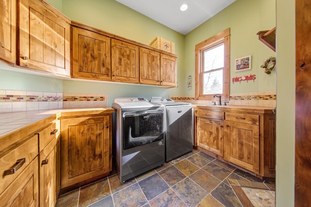 washroom with independent washer and dryer, cabinets, and sink