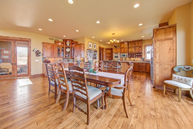 dining space featuring an inviting chandelier and light wood-type flooring