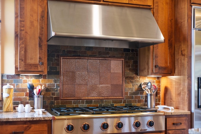 kitchen featuring light stone countertops, range, and decorative backsplash