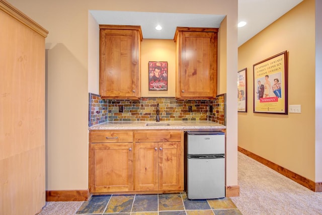 kitchen featuring sink, stainless steel fridge, carpet floors, and tasteful backsplash