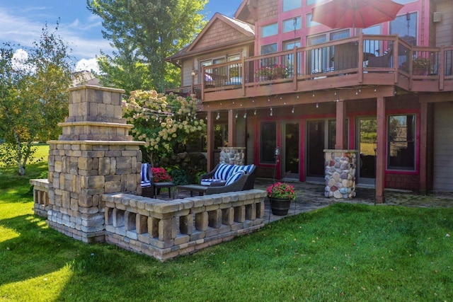 back of house featuring a yard, a wooden deck, and a patio