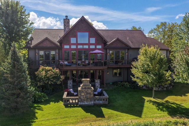 back of property featuring a yard, a deck, a patio, and a fireplace