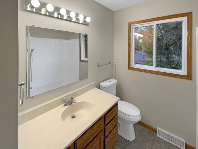 bathroom featuring vanity, toilet, and tile patterned floors