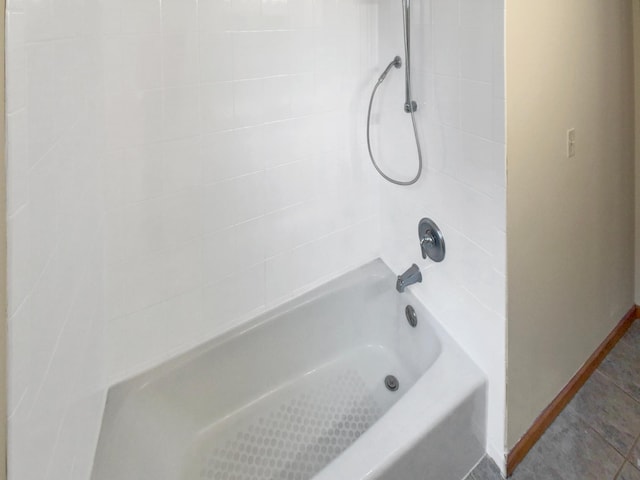 bathroom featuring tiled shower / bath combo and tile patterned flooring