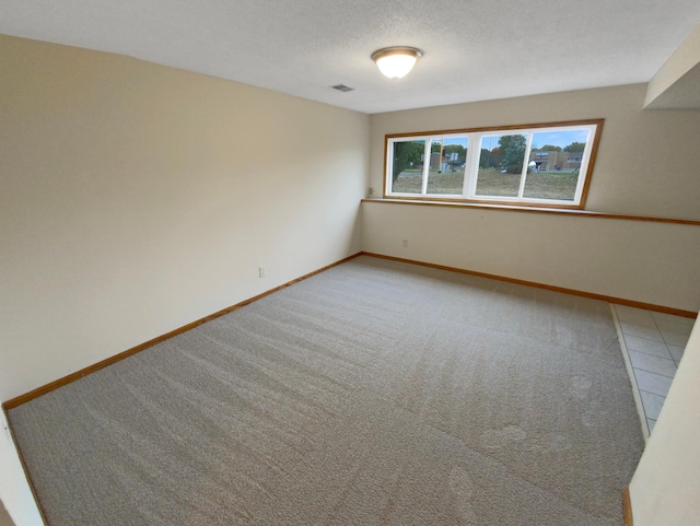 carpeted spare room featuring a textured ceiling