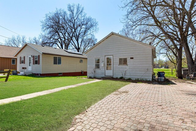 rear view of property featuring a yard and entry steps