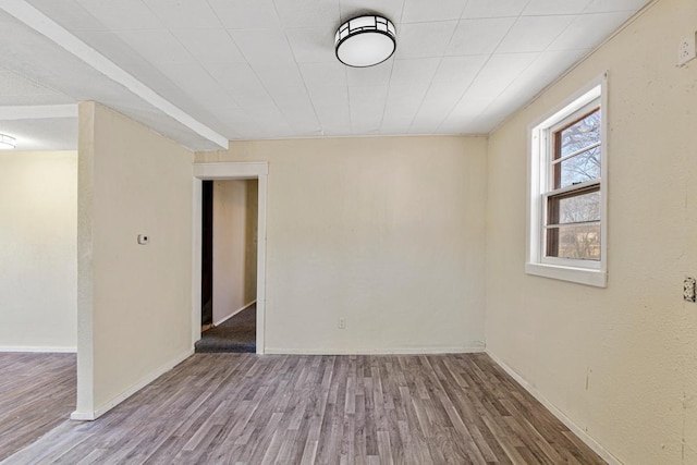 unfurnished room with baseboards and wood finished floors