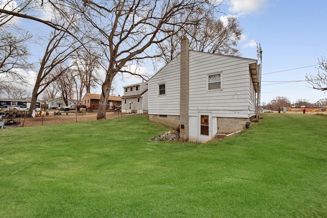 view of side of property featuring a lawn and a chimney