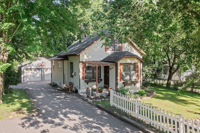 bungalow-style house with an outdoor structure, a garage, and a front yard