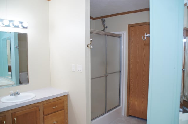 bathroom featuring crown molding, vanity, and walk in shower