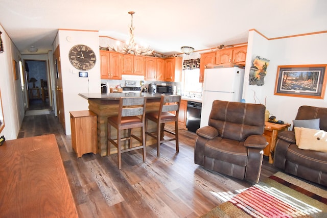 kitchen featuring a breakfast bar area, black appliances, dark hardwood / wood-style floors, and a notable chandelier