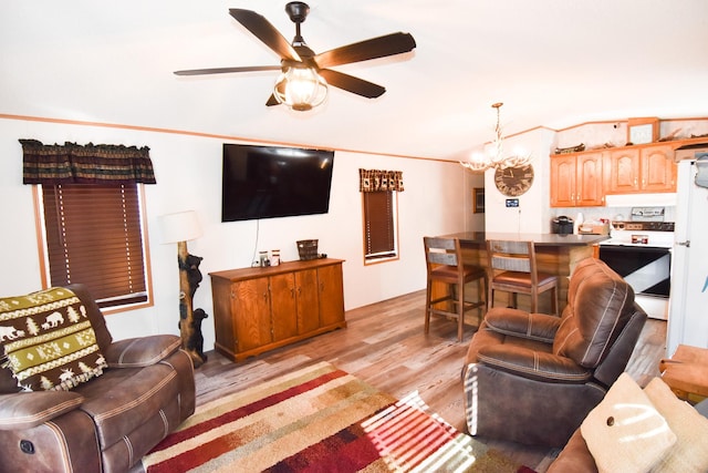 living room with ceiling fan with notable chandelier, ornamental molding, and light hardwood / wood-style flooring