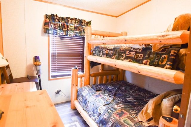 bedroom featuring a textured ceiling, hardwood / wood-style flooring, and crown molding