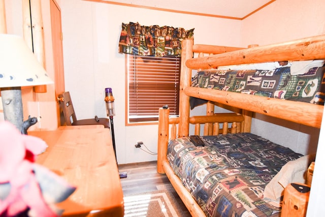 bedroom with hardwood / wood-style floors and crown molding