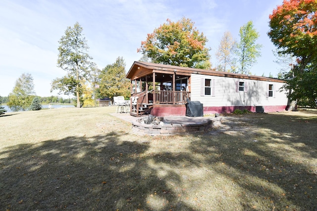 back of property with a yard, a water view, a patio, and cooling unit