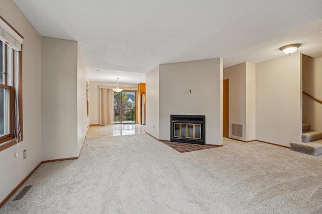 unfurnished living room with carpet floors and a textured ceiling