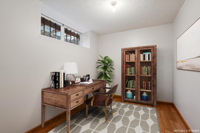 office with a textured ceiling and light hardwood / wood-style flooring