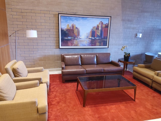 living room with brick wall and carpet