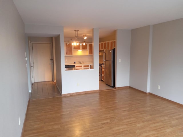 unfurnished living room with sink and light wood-type flooring