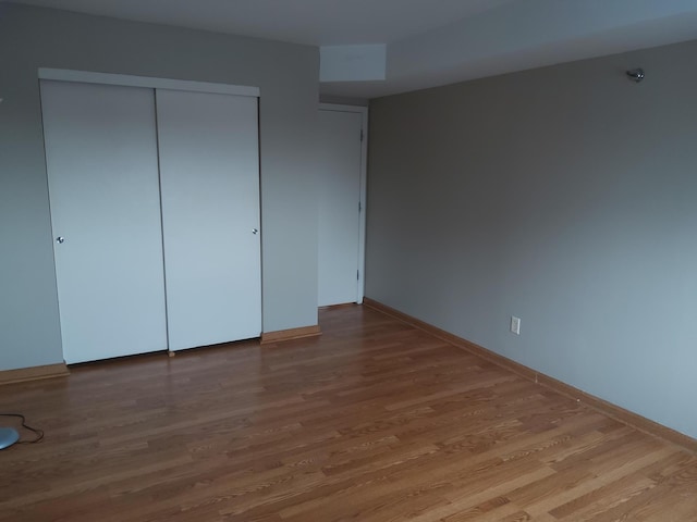 unfurnished bedroom featuring hardwood / wood-style flooring and a closet