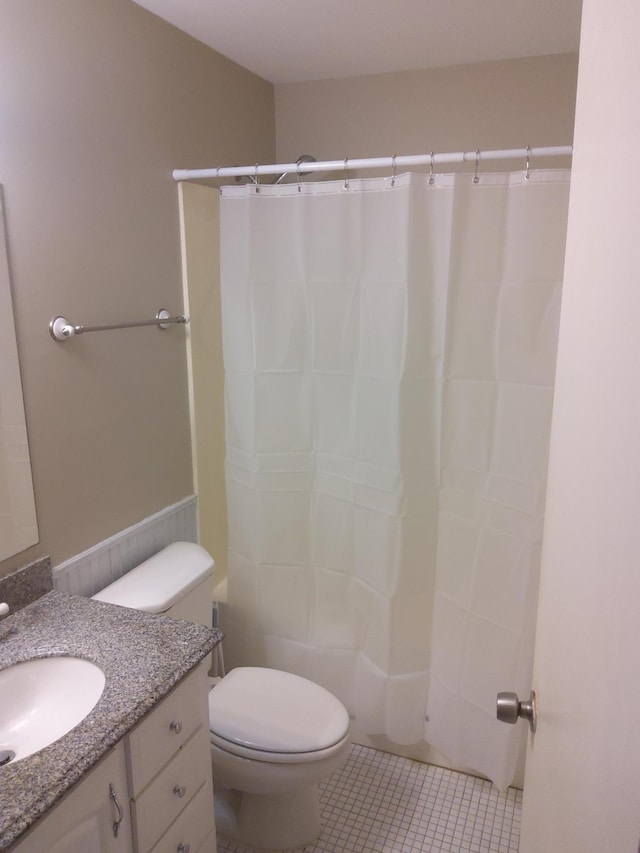 bathroom featuring vanity, tile patterned floors, toilet, and walk in shower