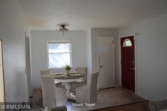 dining room with hardwood / wood-style floors and a textured ceiling