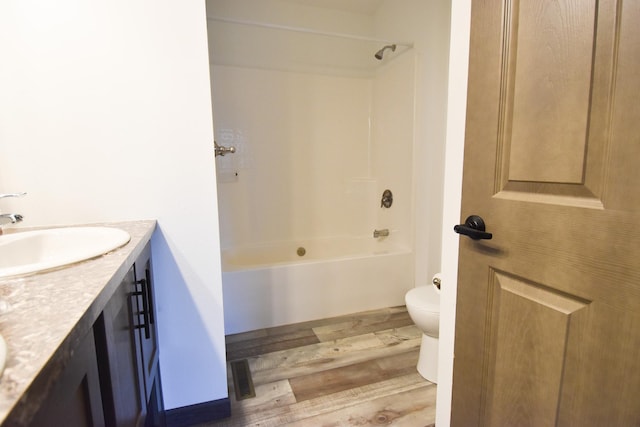 full bathroom featuring hardwood / wood-style floors, vanity, toilet, and shower / washtub combination